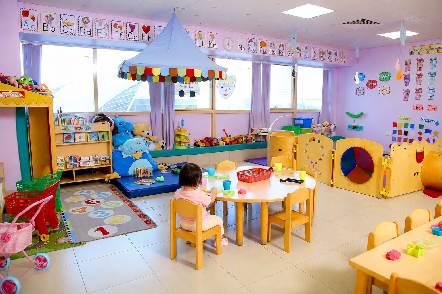 The Early Learners room, with a fabric play canopy, colourful low shelving and child-height tables